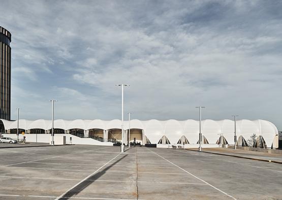 a large white building with a parking lot and street lights