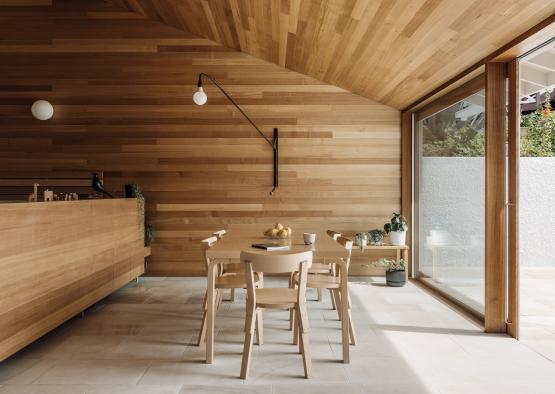 a dining table and chairs in a room with a glass wall