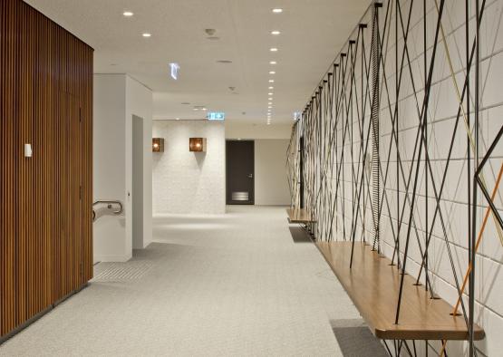 a hallway with a wooden shelf and a white wall