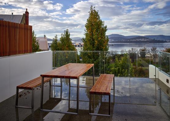 a table and benches on a patio overlooking a body of water