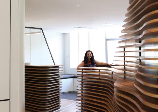 a woman standing behind a wall of wood