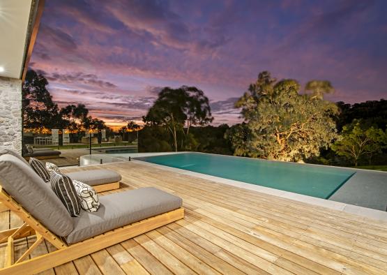 a deck with a pool and a deck with a couch and a bench