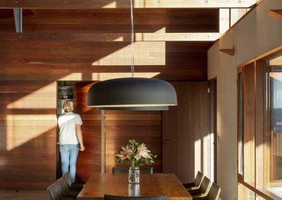 a person standing in a room with a table and chairs