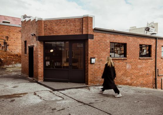 a woman walking in front of a brick building