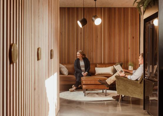 a man and woman sitting on a couch in a hallway