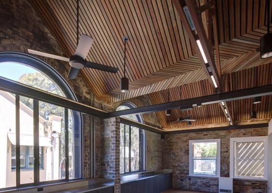 a room with a brick wall and ceiling fan