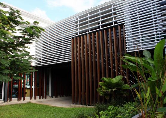 a building with a white wall and green grass