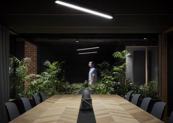 a room with a table and chairs and a man standing in the background