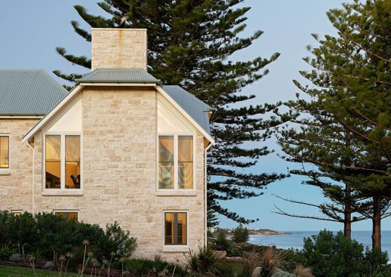 a house with trees and a body of water