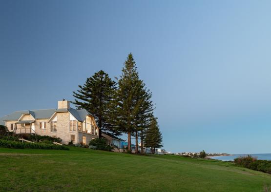 a house on a hill with trees and a body of water