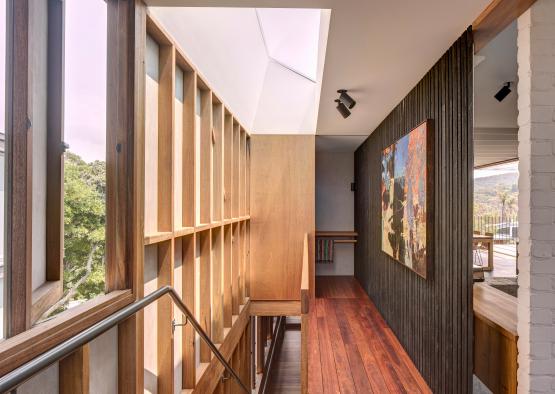 a hallway with wood railings and a bench