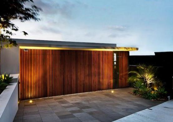 a building with a wood wall and a tile driveway