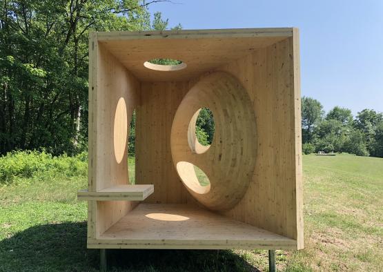 a wooden box with holes and a shelf in the middle of it