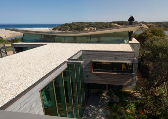 a building with a beach and water in the background