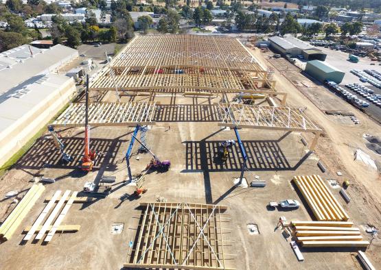 a building under construction with cranes and a lot of wood