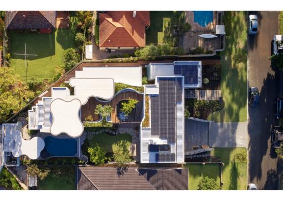 a house with solar panels and a pool in the middle of a yard