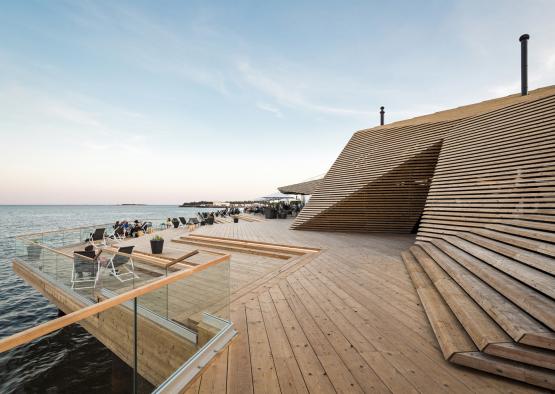 a wooden deck with a building and a body of water