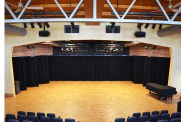 a stage with black curtains and a wooden floor